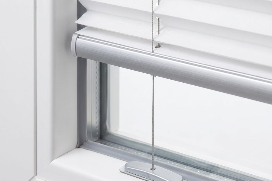 Unterschiene eines weißen Plissees mit Spannschuh am Fensterrahmen